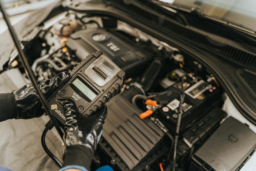 Technician using a diagnostic tool on a diesel engine in a workshop