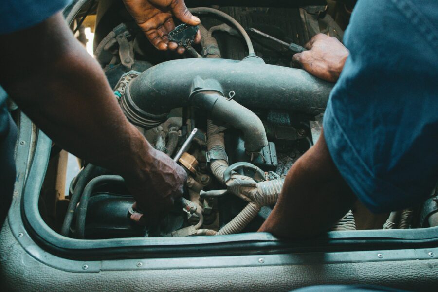 Diesel mechanics working on a truck engine powertrain during maintenance