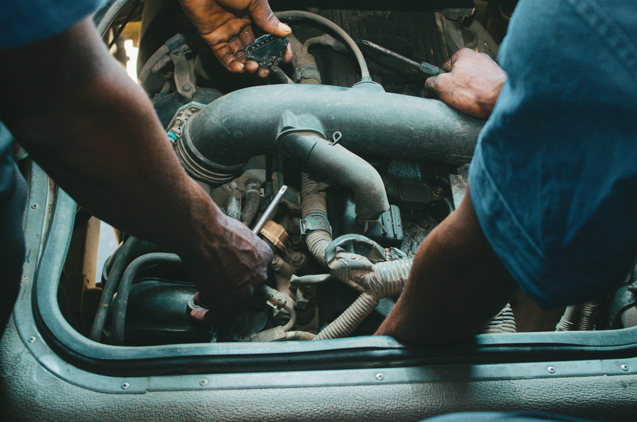 Diesel mechanics working on a truck engine powertrain during maintenance
