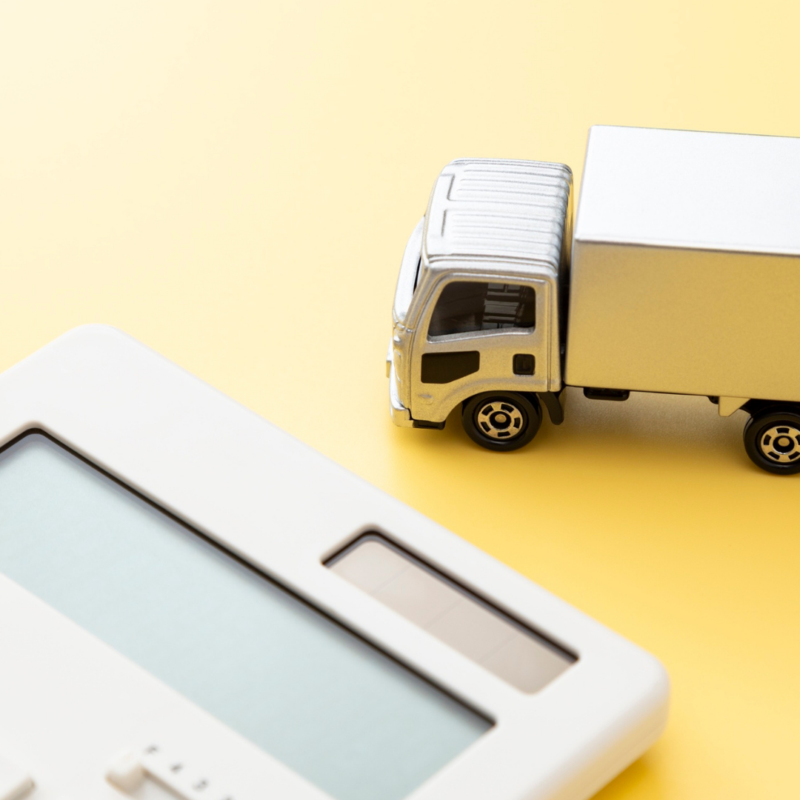 Small white delivery truck next to a calculator on a yellow background, symbolising turbo upgrade expenses.