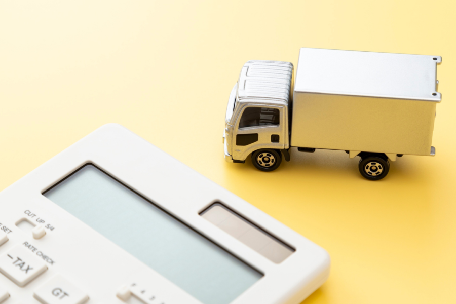 Small white delivery truck next to a calculator on a yellow background, symbolising turbo upgrade expenses.