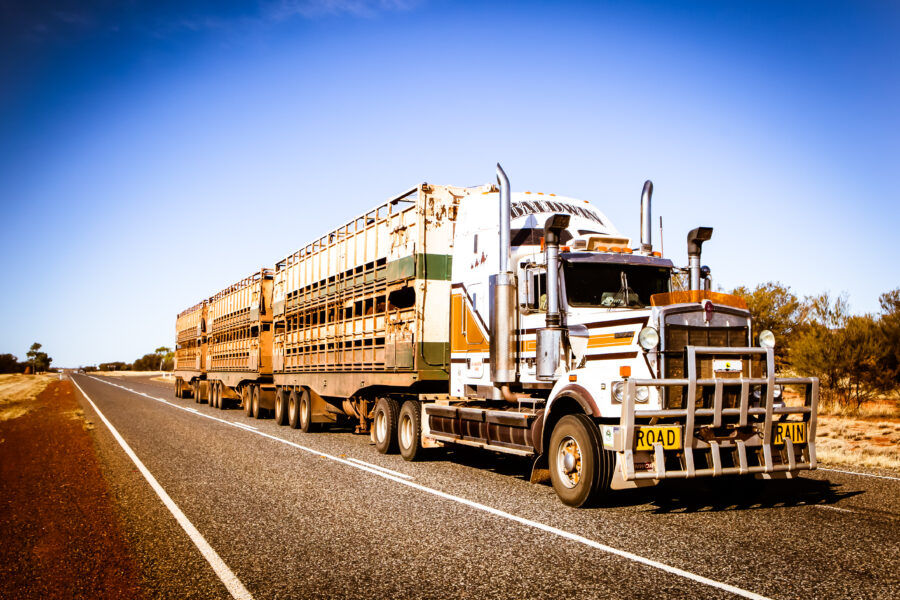 Semi truck driving through Australian outback highway highlighting real world truck service warning signs and long haul reliability.